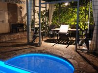 Barbacoa junto al cenador y la piscina en la casa rural La Fuente Gorda, en Navas de Estena, Parque Nacional de Cabañeros.