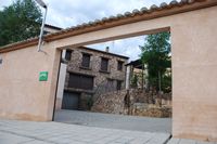 Vista general de La Fuente Gorda desde su puerta trasera: patio, solárium sobreelevado, cenador y las tres plantas de casa.