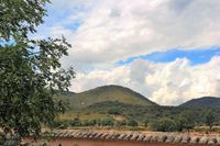 Vistas del Parque Nacional de Cabañeros desde La Fuente Gorda. Delante, tras la pared del patio, se ven pastando unas vacas. Vistas del Parque Nacional de Cabañeros desde La Fuente Gorda. Delante, tras la pared del patio, se ven pastando unas vacas.