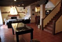 Salón de 80 m2 de La Fuente Gorda con, desde la izquierda, mesa expositora, chimenea, cocina, comedor y zonaTV (fuera de campo).