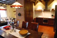 Comedor y cocina de la casa rural La Fuente Gorda, al fondo a la izquierda la zona de chimenea con su ventanal.