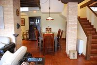 Zona de comedor al lado de la cocina y escalera de acceso a los cuatro dormitorios con baño de la casa rural La Fuente Gorda.