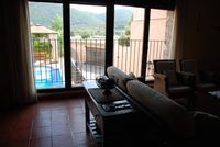 Ventanal del salón de La Fuente Gorda, con vistas a la piscina y el patio delante y el Parque Nacional de Cabañeros al fondo.