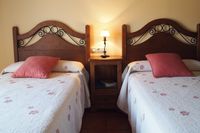 Habitación “Tierra” de la casa rural La Fuente Gorda en Navas de Estena. Tiene balcón con vistas a piscina y al Parque Nacional.