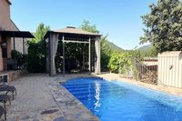 Solárium de La Fuente Gorda. De izquierda a derecha, hamacas, barbacoa, cenador, piscina, vistas de Cabañeros y leñera.