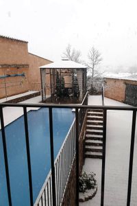 Patio nevado de la casa rural La Fuente Gorda, en Navas de Estena. A la izquierda, piscina, solárium y cenador.