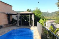 Piscina, cenador, barbacoa y golondrinas de la casa rural La Fuente Gorda. Al fondo, el Parque Nacional de Cabañeros.