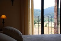 Parque Nacional de Cabañeros a través del balcón desde la cama de la habitación “Aire” de la casa rural La Fuente Gorda.