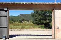 Puerta de acceso al patio de La Fuente Gorda, en Navas de Estena. Ermita y Parque Nacional de Cabañeros al fondo.