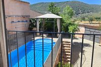 Patio soleado de La Fuente Gorda. A la izquierda, piscina, solárium y cenador. Al fondo, el Parque Nacional de Cabañeros.